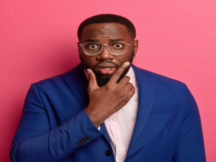 successful-black-male-entrepreneur-looks-shocked-camera-holds-chin-wears-formal-blue-suit-has-speechless-look